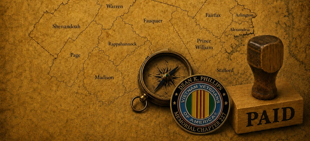 A Dean K. Phillips Memorial Chapter 227 challenge coin and a compass resting on a map of the Northern Virginia counties and cities the chapter serves — Fairfax, Arlington, Alexandria, Prince William, and beyond.