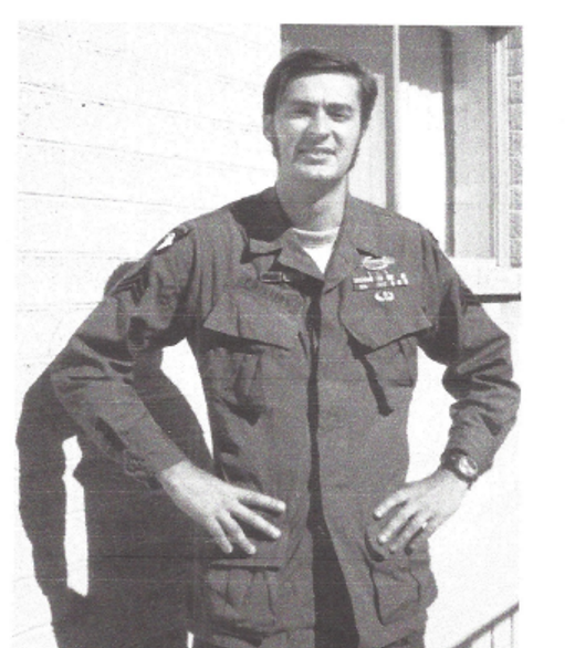 A black-and-white photograph of Sgt. Dean K. Phillips in uniform, hands on hips, standing on a porch.